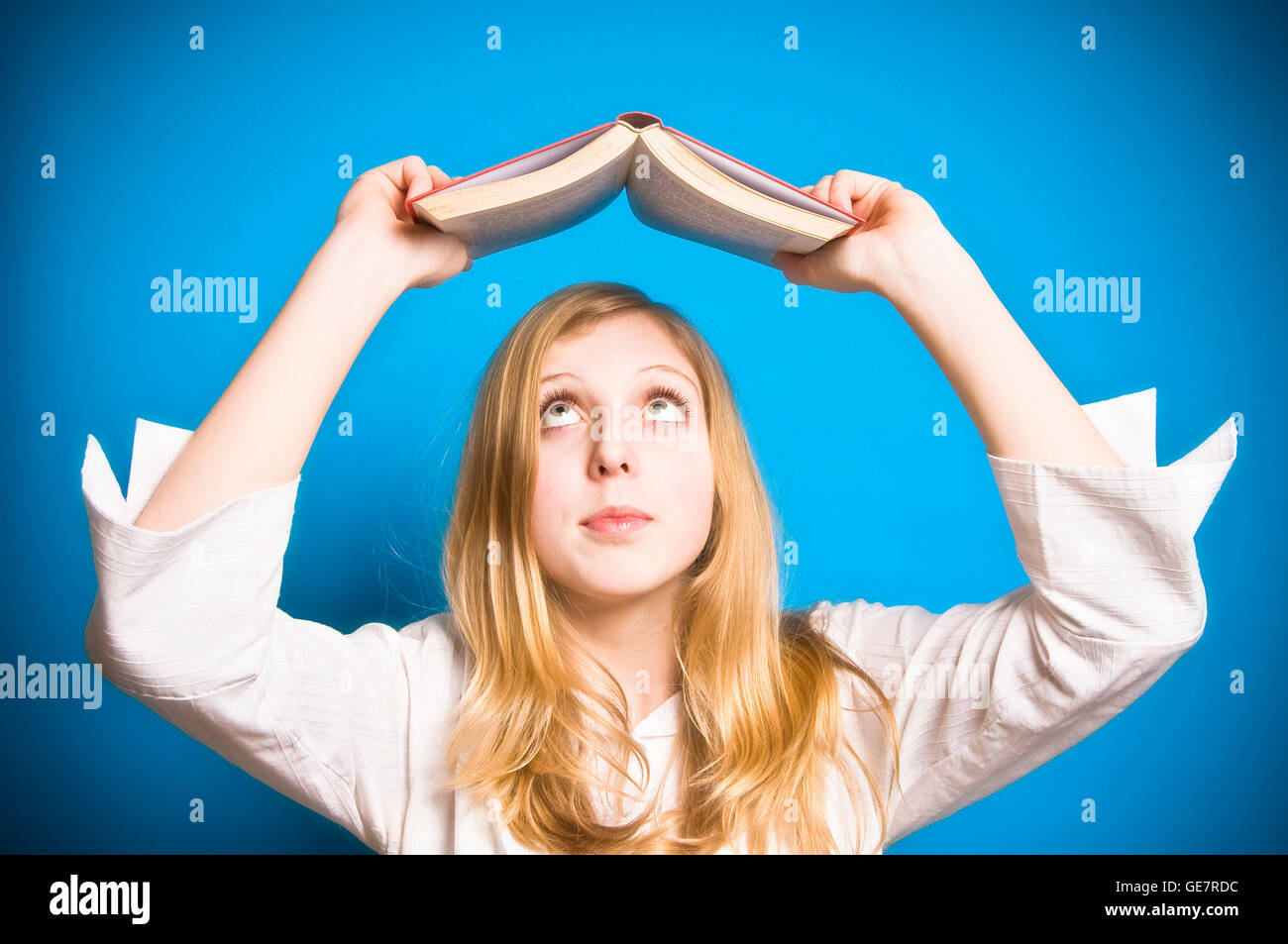 girl holding a book over her head Stock Photo - Alamy
