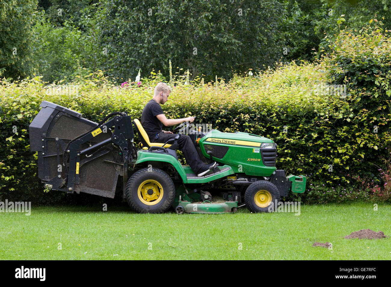 Man mowing the Lawns on a tractor lawn mower Stock Photo