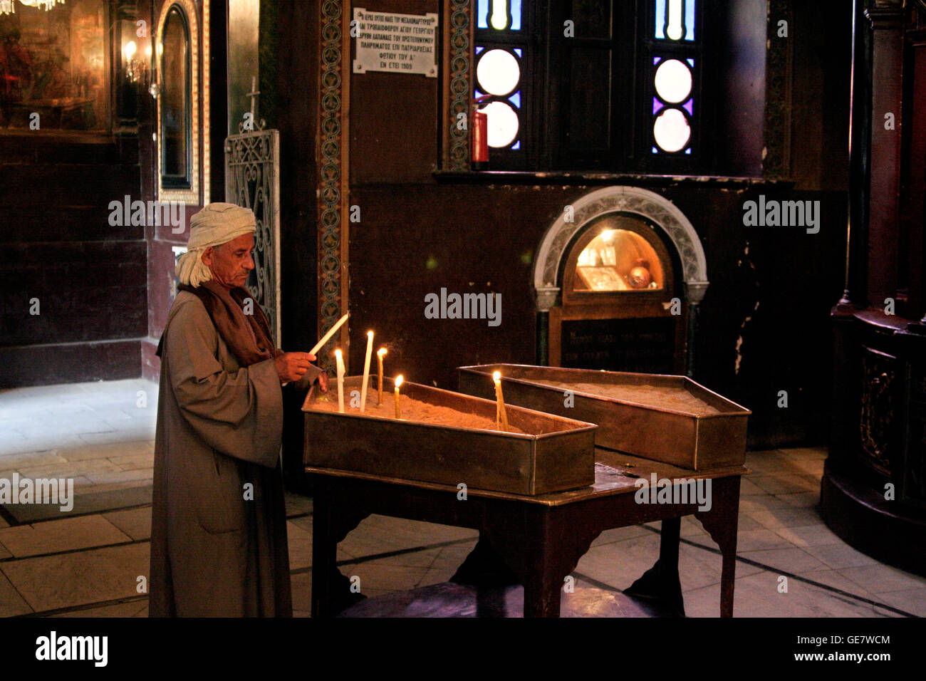 Christianity Coptic Man lighting a candle. Greek Orthodox Church and