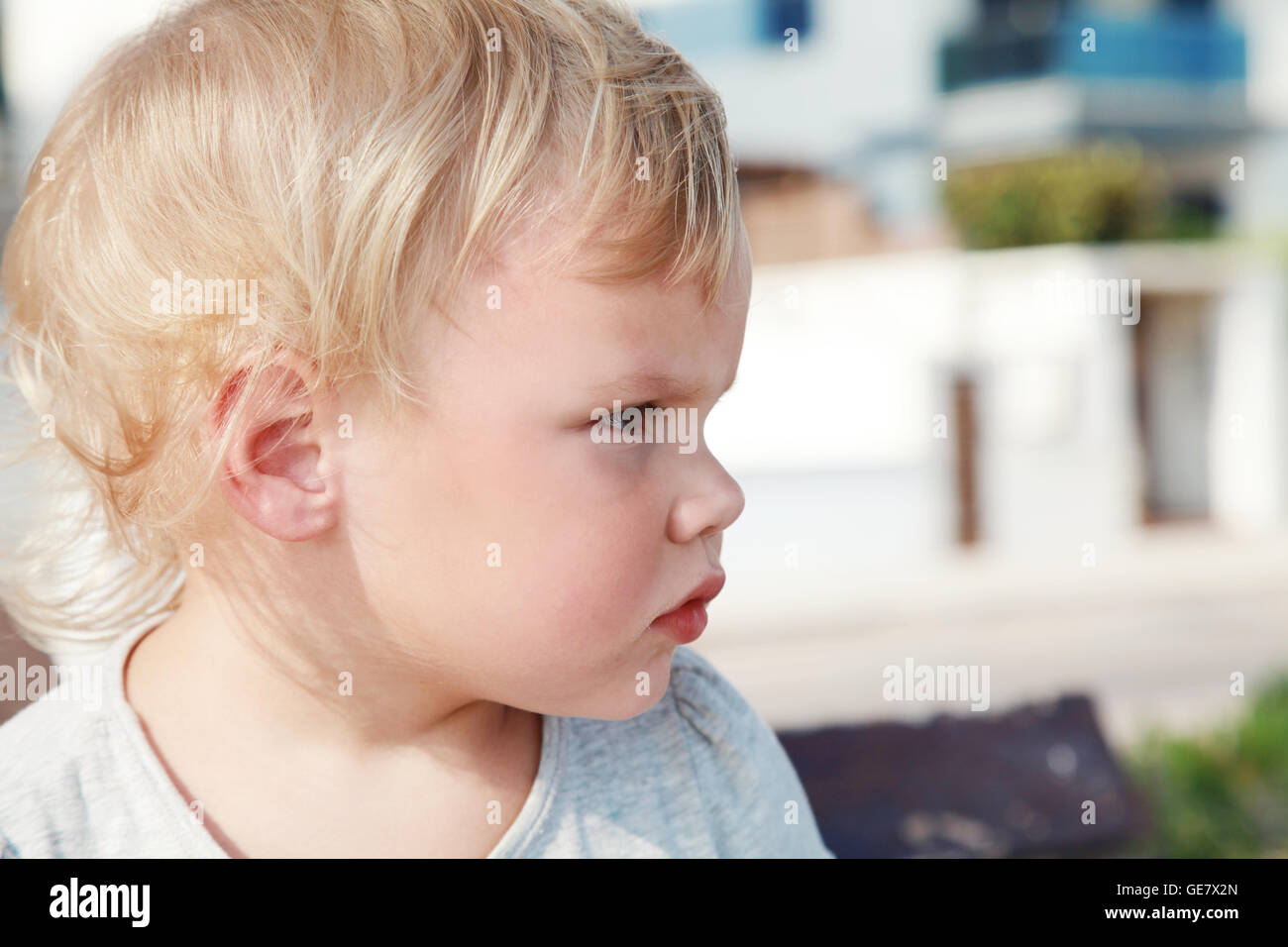 Outdoor close up profile portrait of serious cute Caucasian blond baby ...
