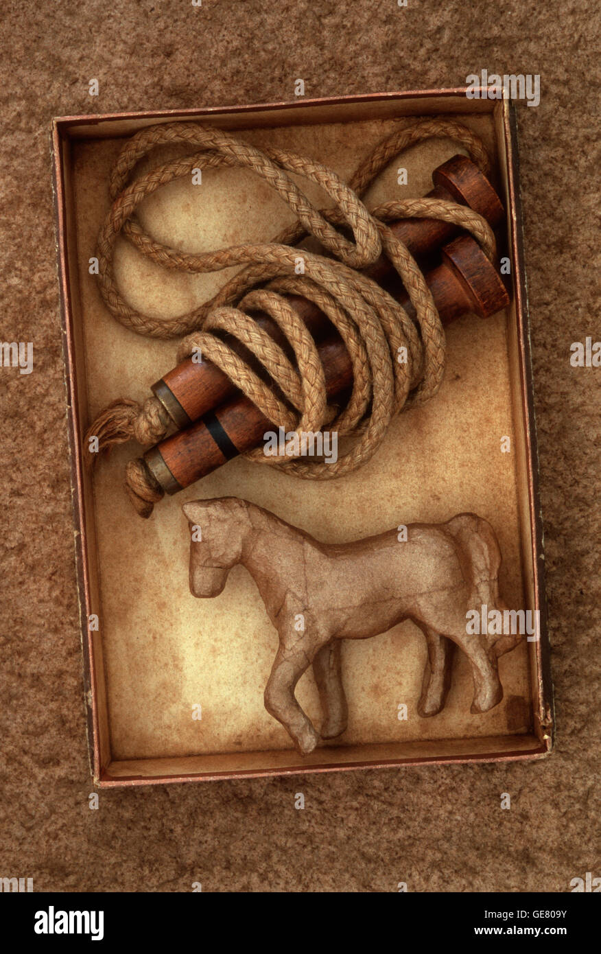 Cardboard box containing Victorian skipping rope and stained papier mache model of horse Stock Photo