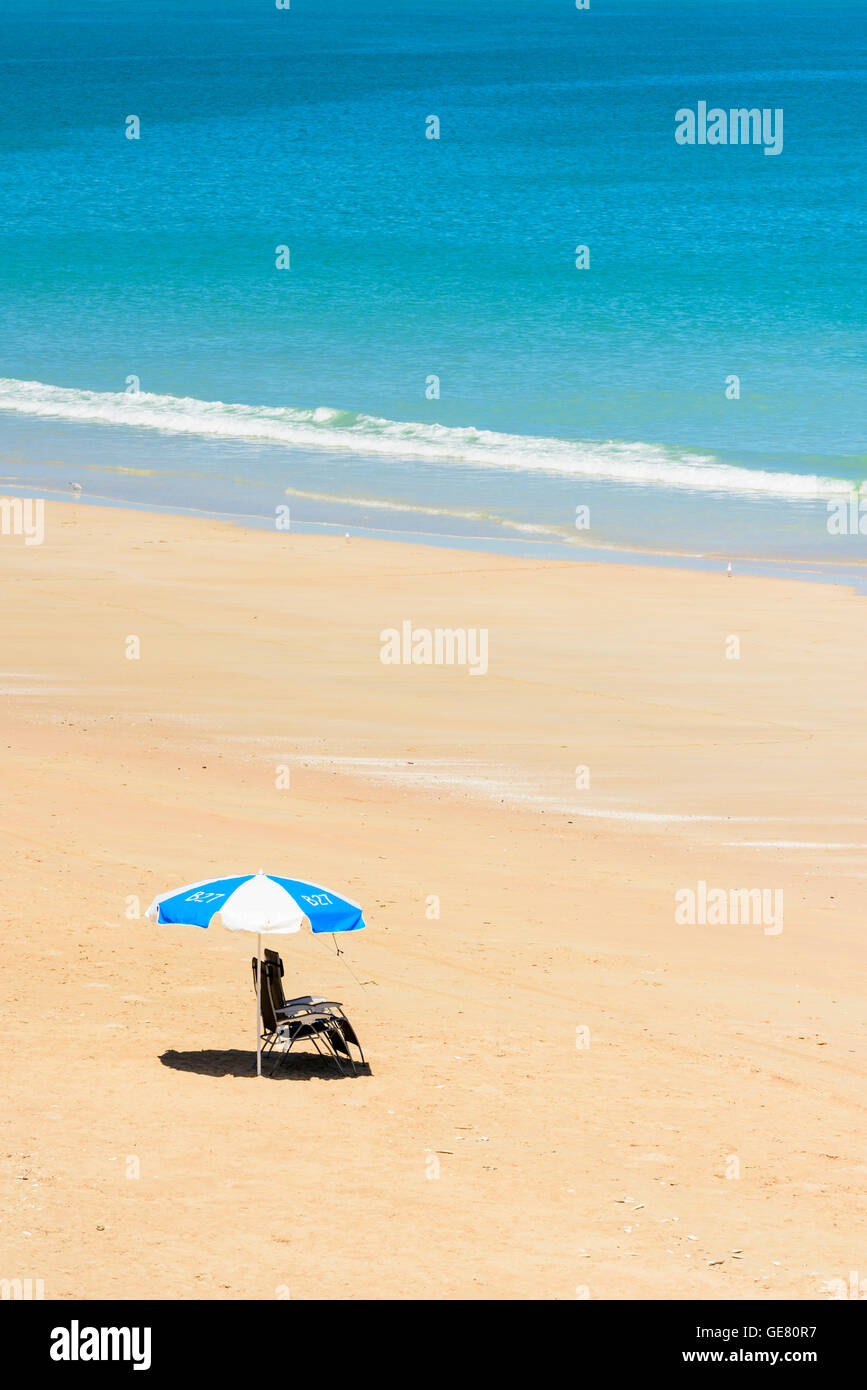 Two empty deckchairs and shade umbrella on Cable Beach, Broome, Kimberley, Western Australia Stock Photo