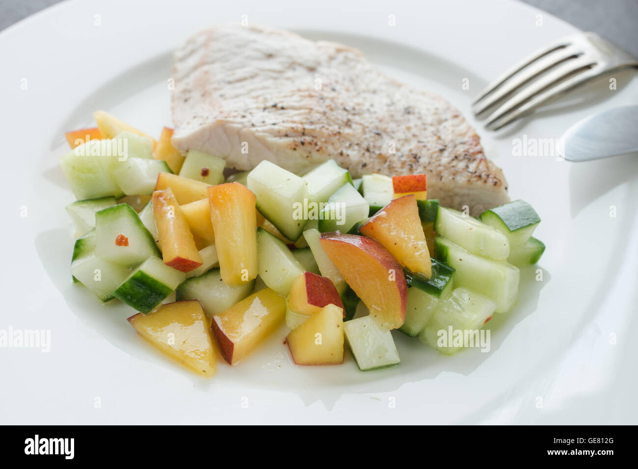 Low carb main dish turkey escalope with fruit salad of cucumber and nectarines Stock Photo Alamy