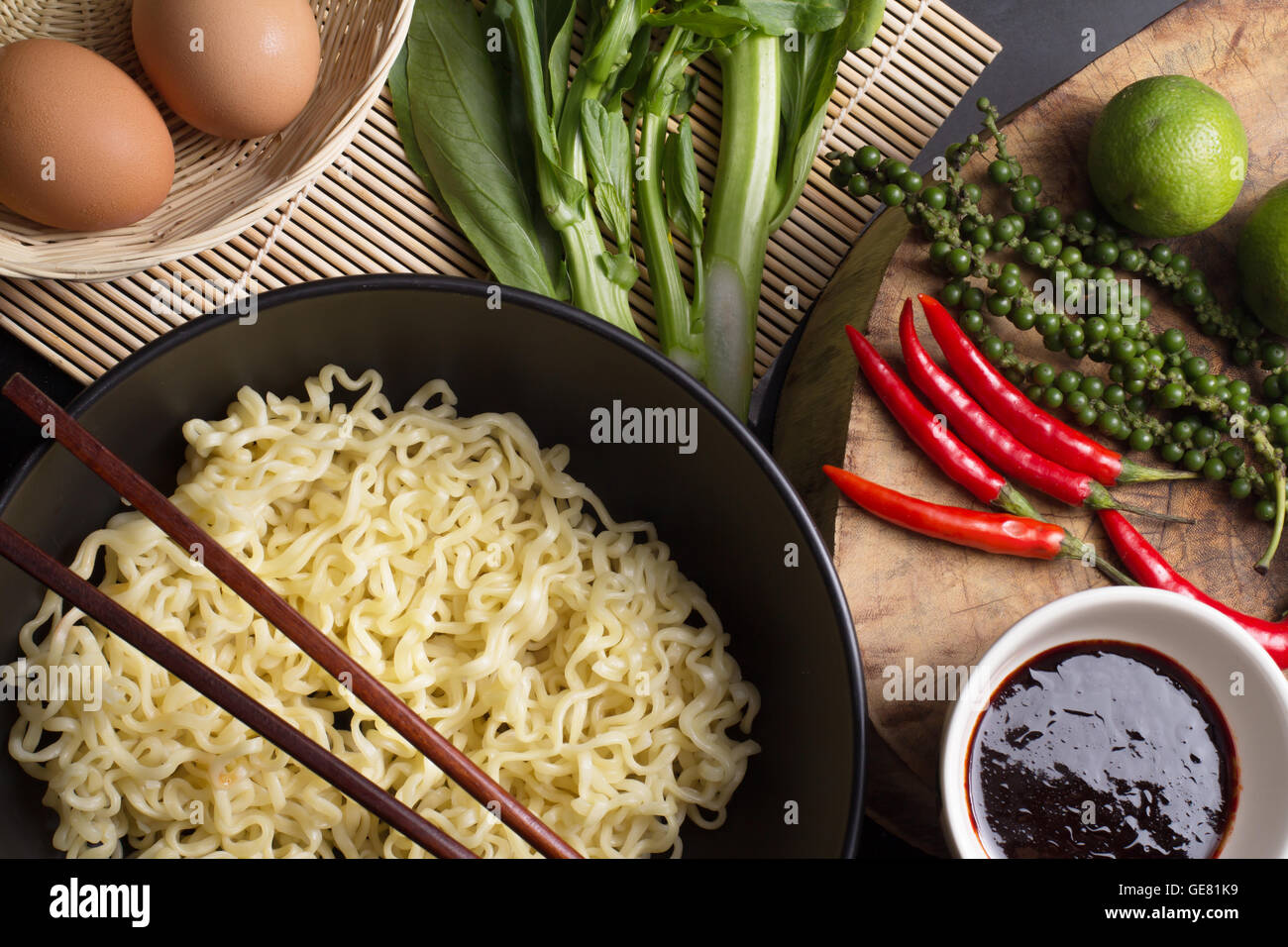 noodles in black bowl garnished on kitchen table Stock Photo