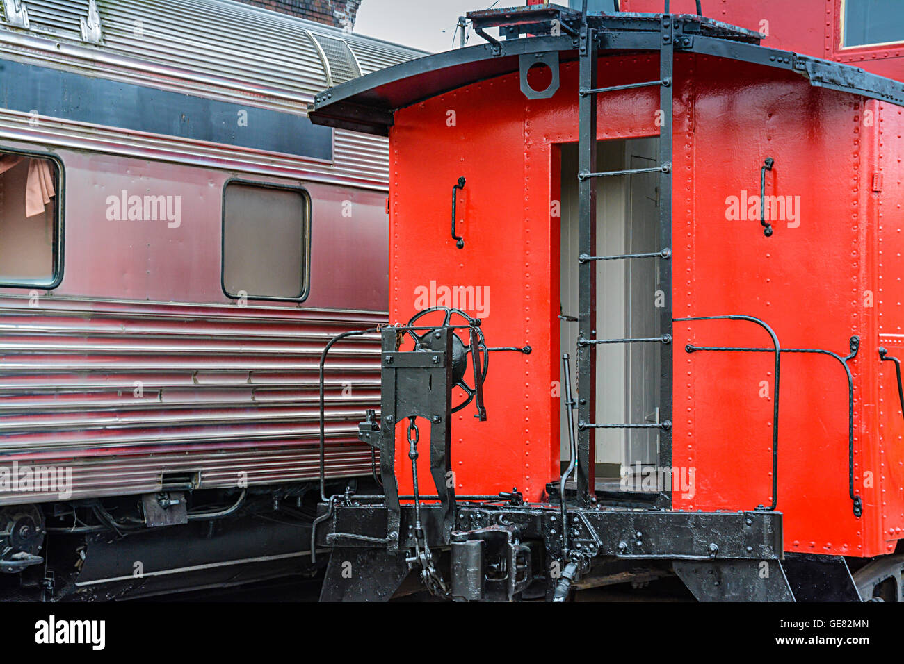 A view of the rear of a bright red vintage train Caboose alongside an