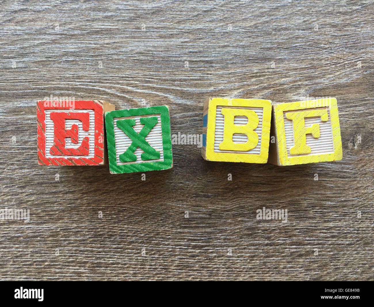 Wood blocks or wooden cubes toys with alphabet letters on them combined together to create the word EX BF Stock Photo