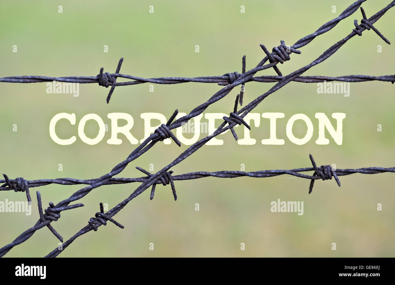 Word Corruption written under a wire fence with barbs Stock Photo