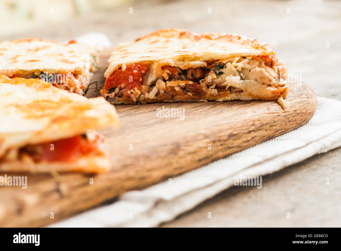 pile of quesadillas with chicken and vegetables on the rustic board. Stock Photo