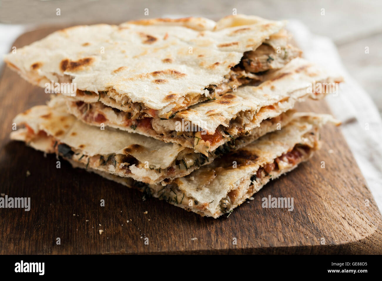 pile of quesadillas with chicken and vegetables on the rustic board. Stock Photo
