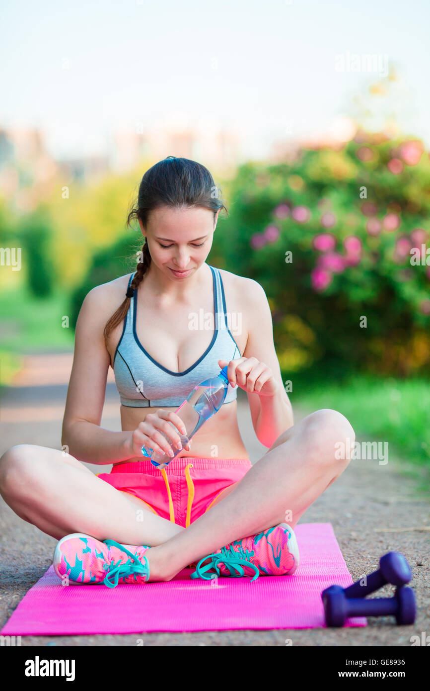 Fitness young woman meditating in the park. Female fitness model