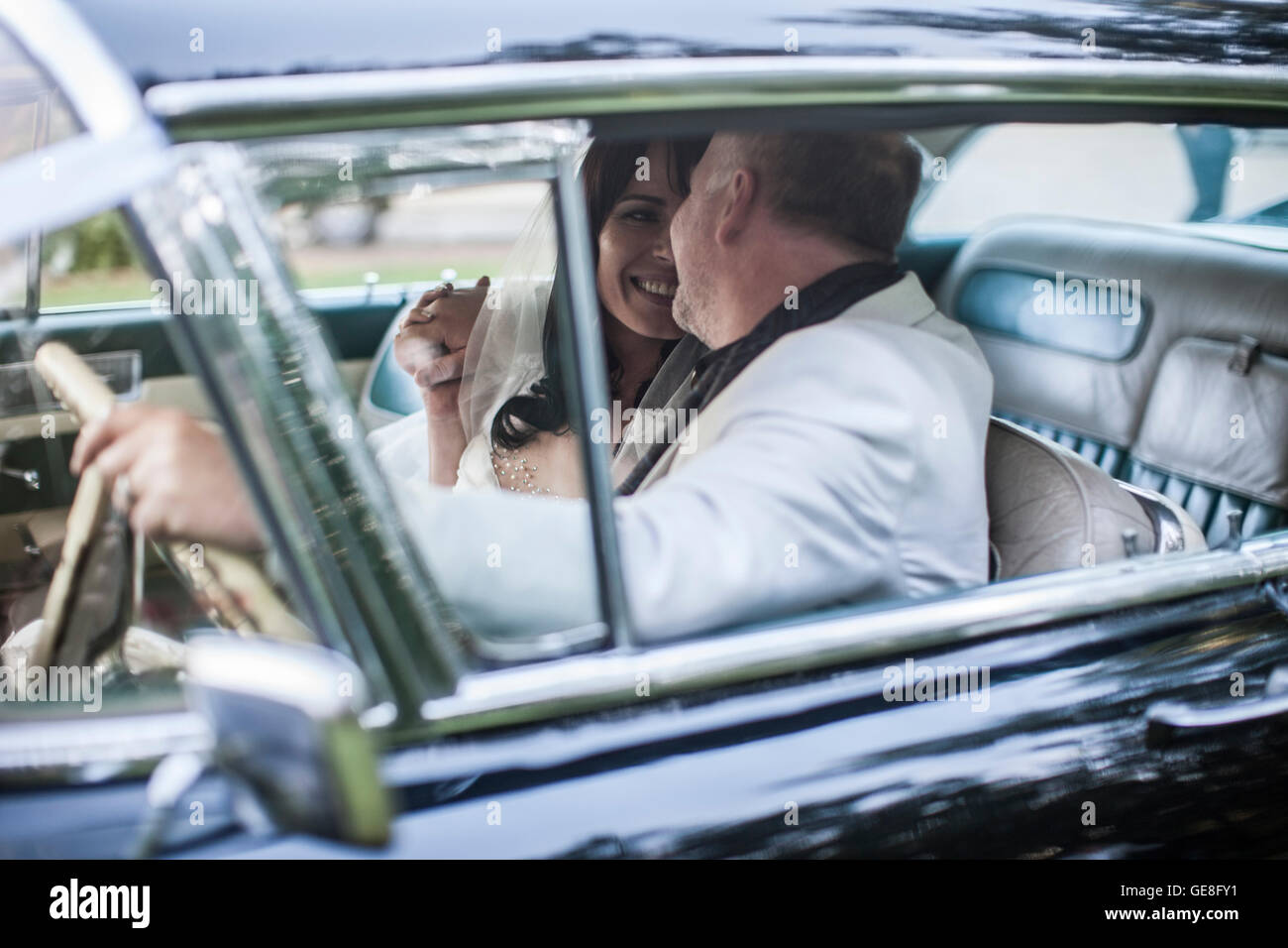 Bride and groom sitting in vintage car Stock Photo - Alamy