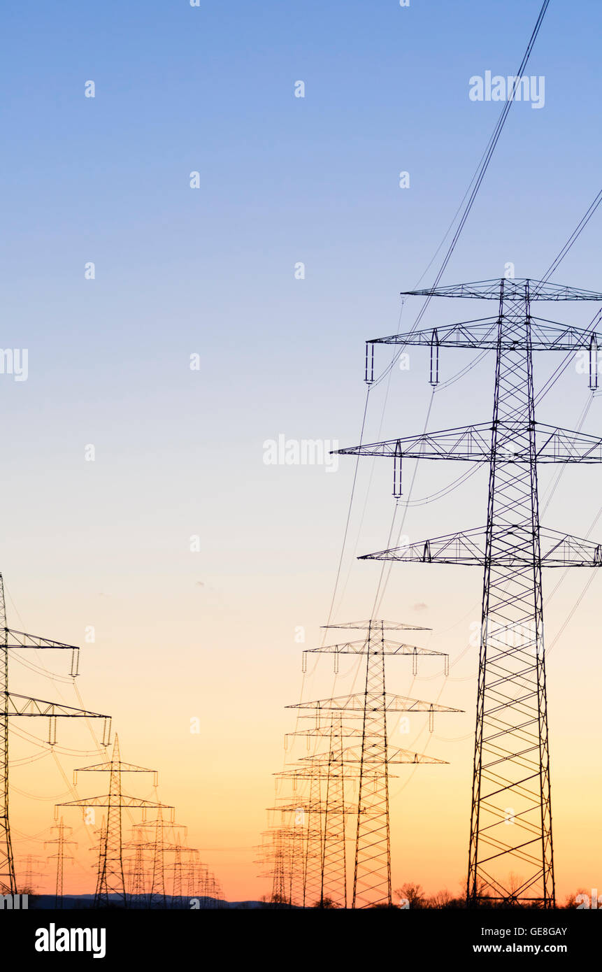High voltage power lines pylon sunset energy Stock Photo - Alamy
