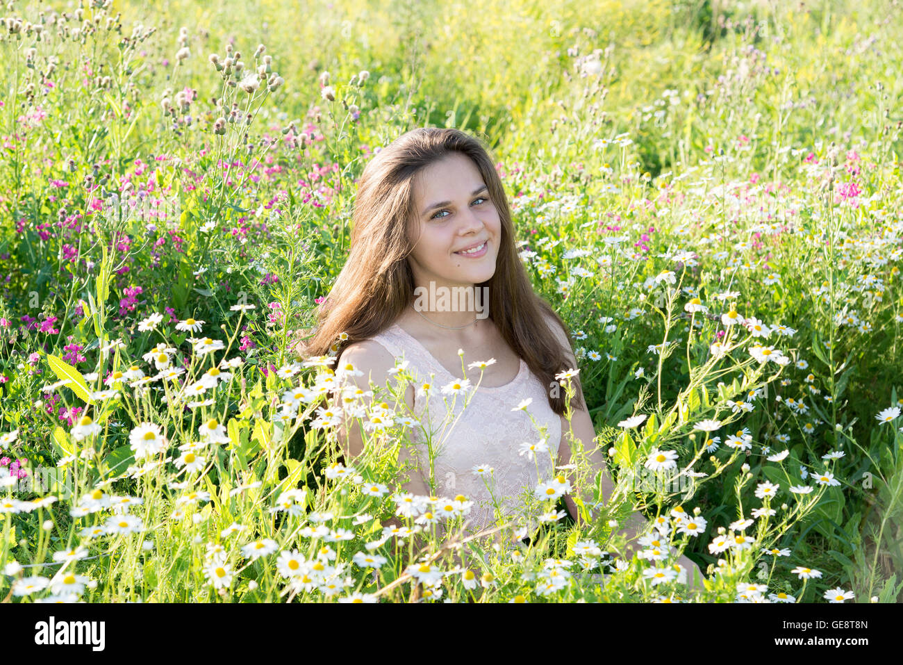 girl sits on meadow with wild flowers Stock Photo - Alamy