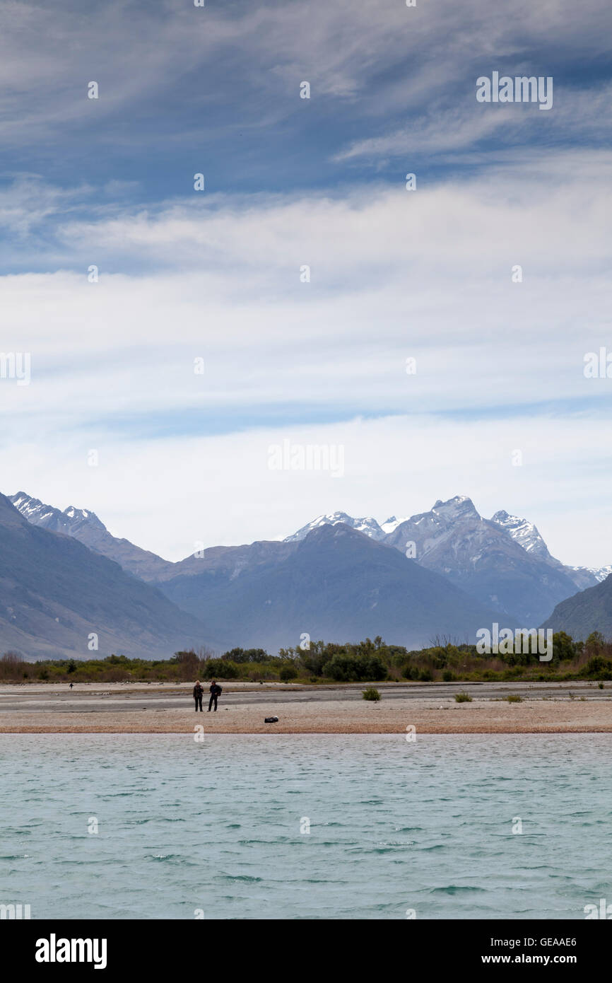 Couple standing on the lake shore at Glenorchy, New Zealand Stock Photo