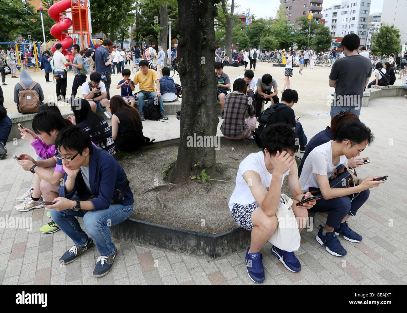 Tokyo Japan 24th July 16 Men And Women Young And Not So Old Are Absorbed In Playing The Pokemon Go Smartphone Game At A Downtown Tokyo Park On Sunday July 24 16 Since Its