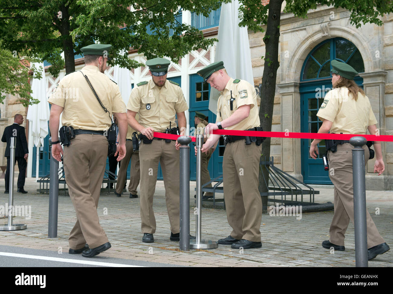 Bayreuth, Germany. 25th July, 2016. Polizisten stehen am 25.07.2016 in Bayreuth (Bayern) vor der Eröffnung der Richard-Wagner-Festspiele vor dem Festspielhaus an einer Absperrung. Nach dem Amoklauf von München startet das berühmte Opernfestival in Bayreuth in diesem Jahr ohne roten Teppich und den traditionellen Staatsempfang. Foto: Timm Schamberger/dpa/Alamy Live News Stock Photo