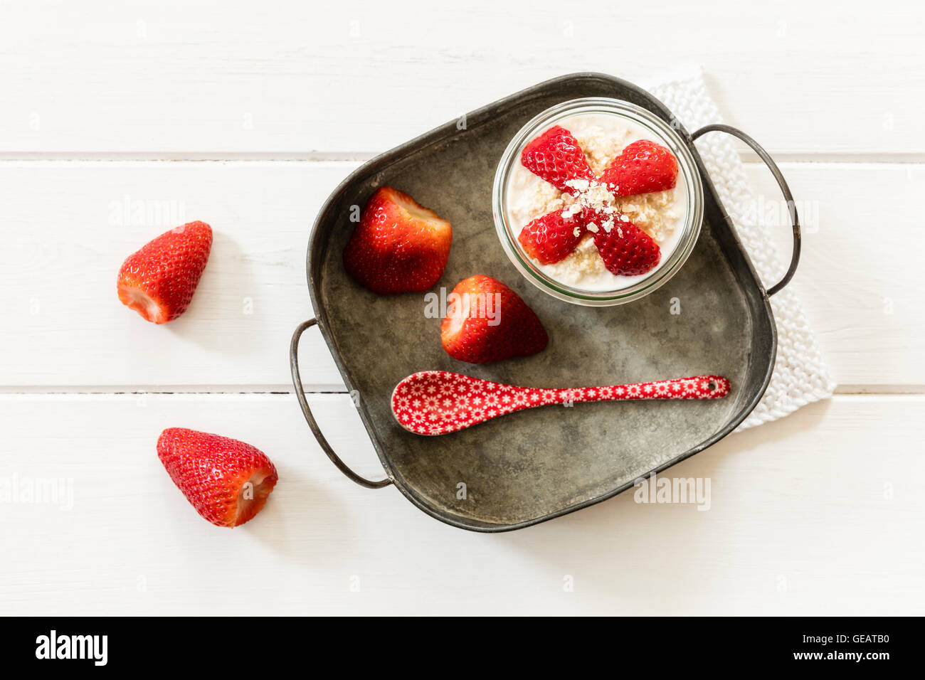 Glass of overnight oats with strawberries on metal tray Stock Photo