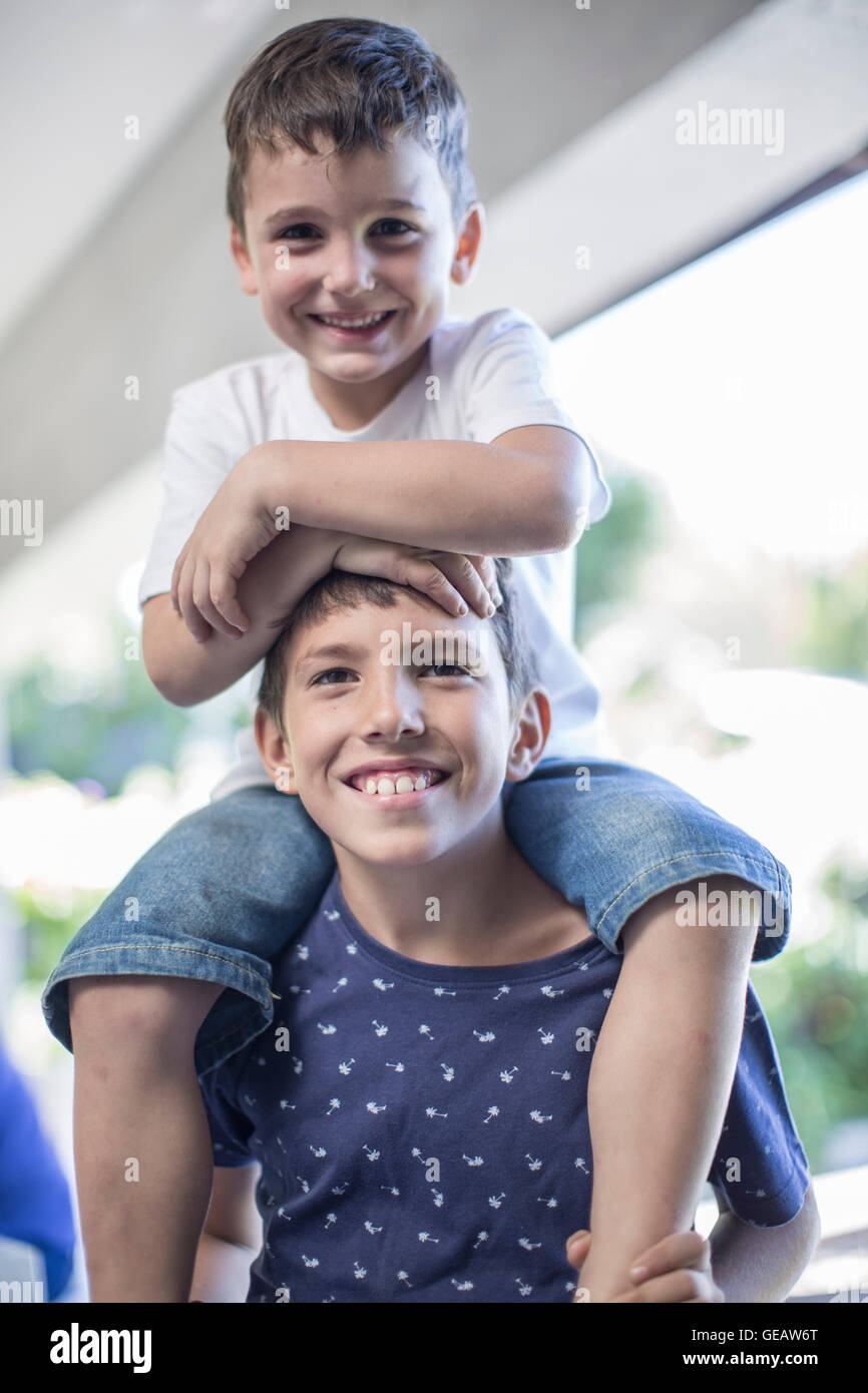 Little boy sitting on his brother's shoulders Stock Photo Alamy