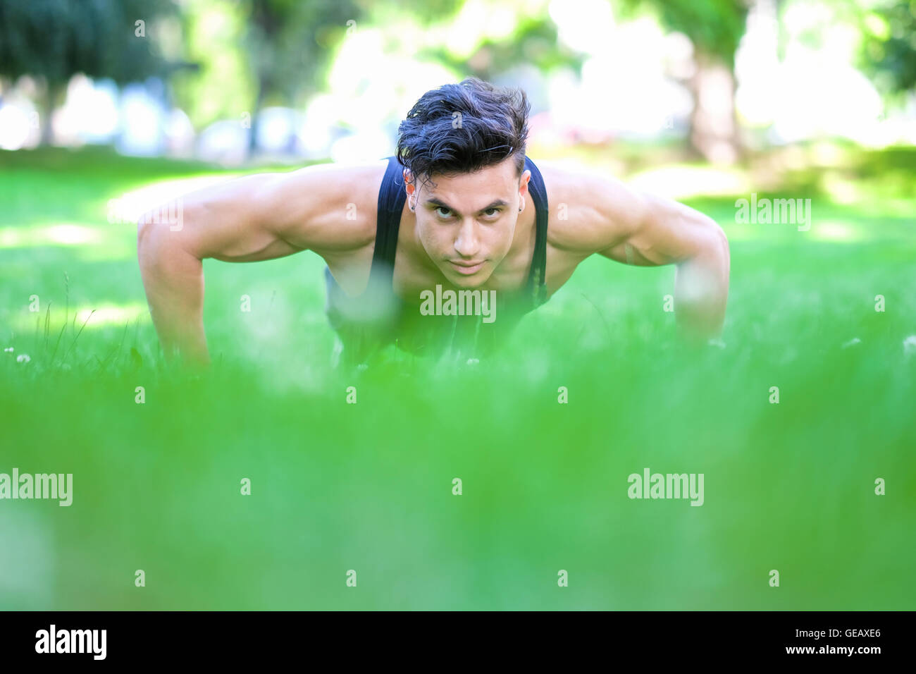 Young man doing push-ups in meadow Stock Photo - Alamy