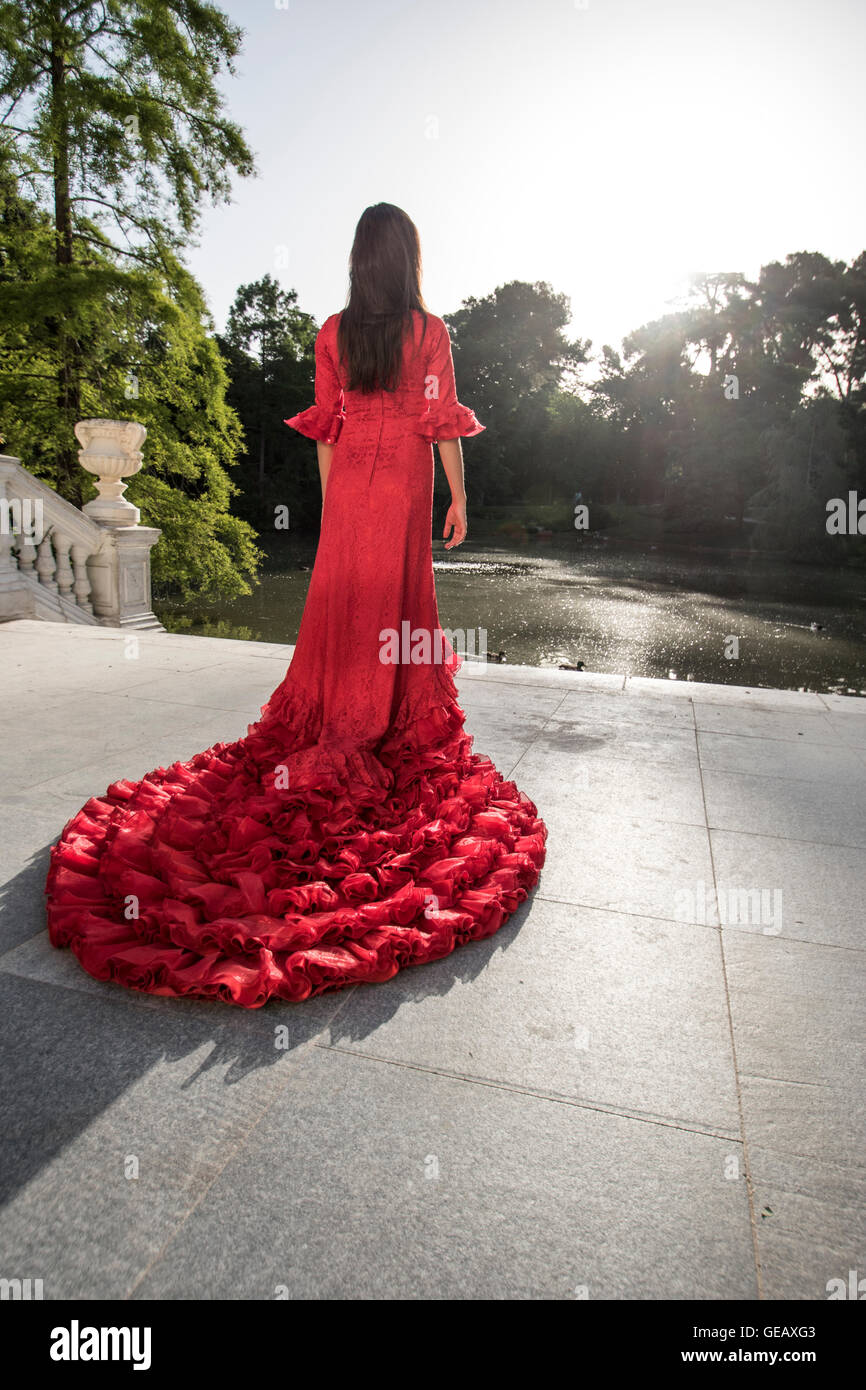Back view of woman weraing red Bata de Cola standing on a terrace Stock Photo