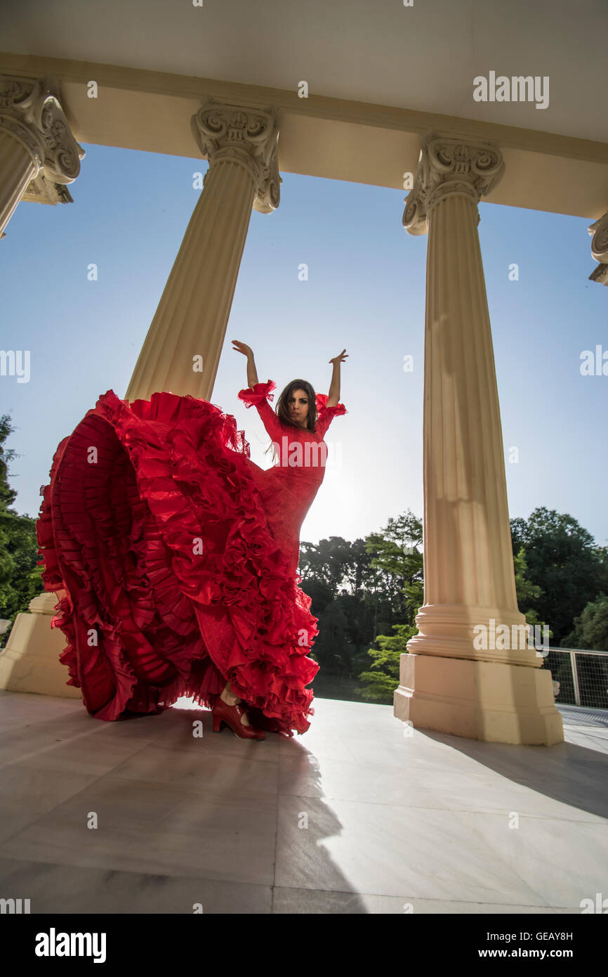 Woman dressed in red dancing flamenco on terrace at backlight Stock Photo