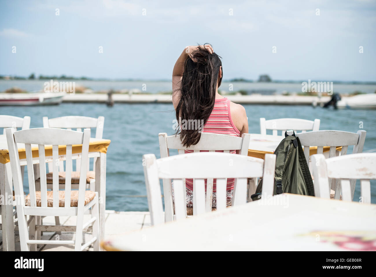 Greece, Lefkada, woman sitting in a Greek taverna by the sea Stock Photo