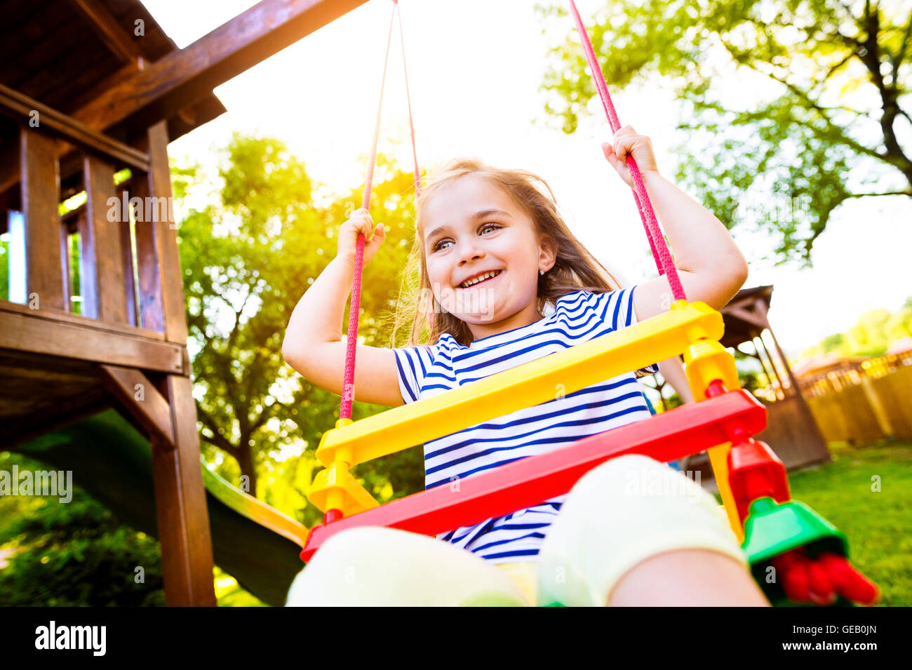 Portrait of happy little girl on a swing Stock Photo - Alamy