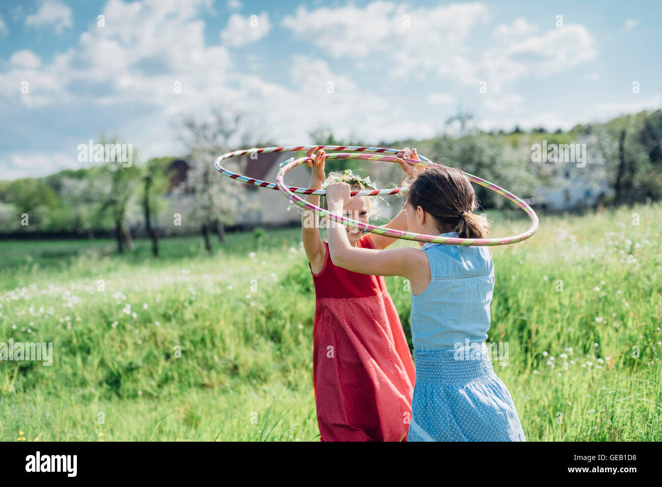 Two girls with hula hoops in meadow Stock Photo