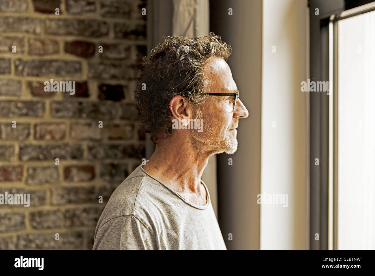Man looking through window Stock Photo Alamy