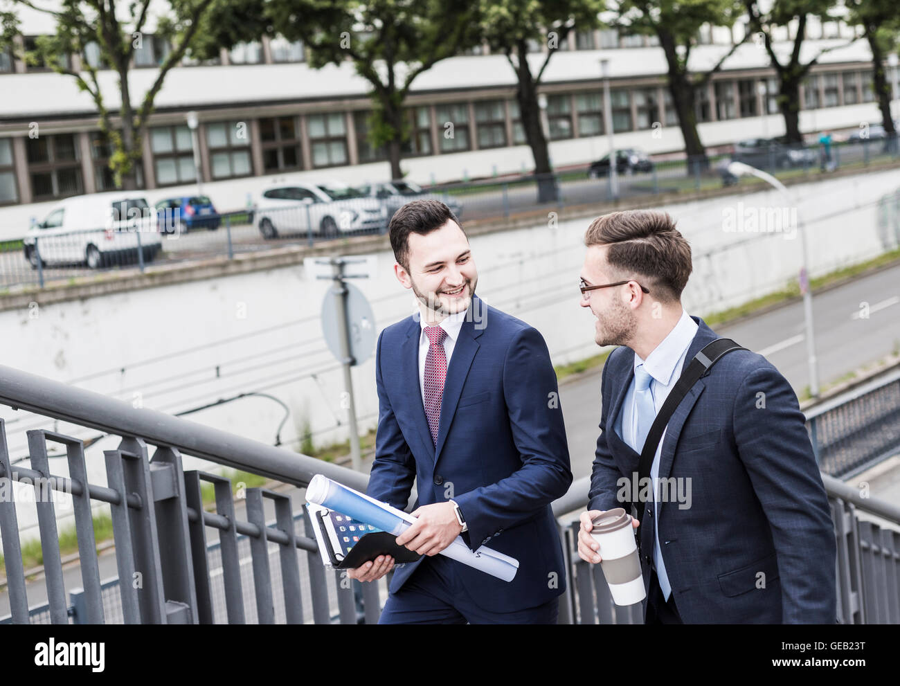 Two young businessmen walking together in the city Stock Photo - Alamy