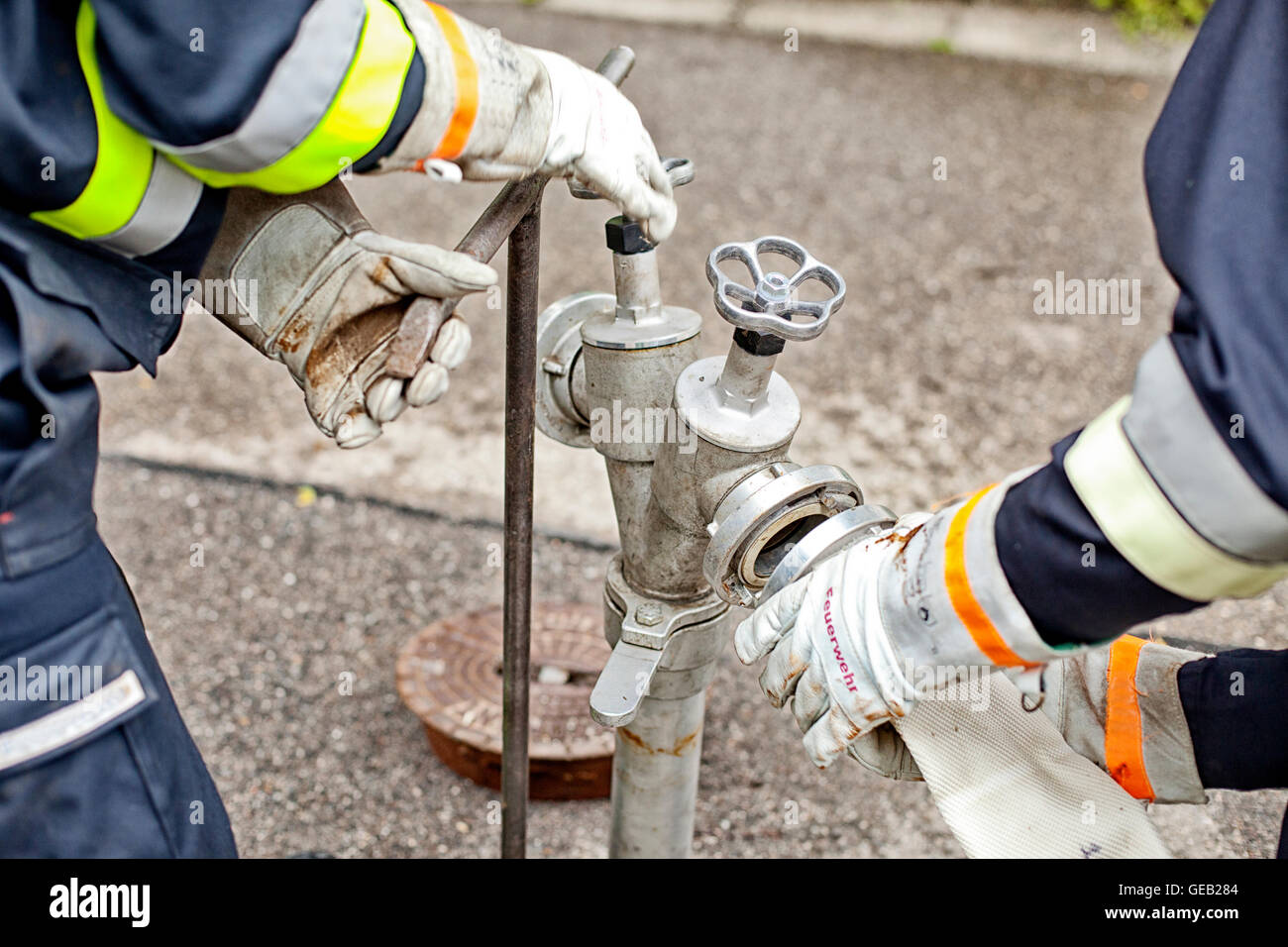 Closeup of firefighters connecting hose to fire hydrant Stock Photo Alamy