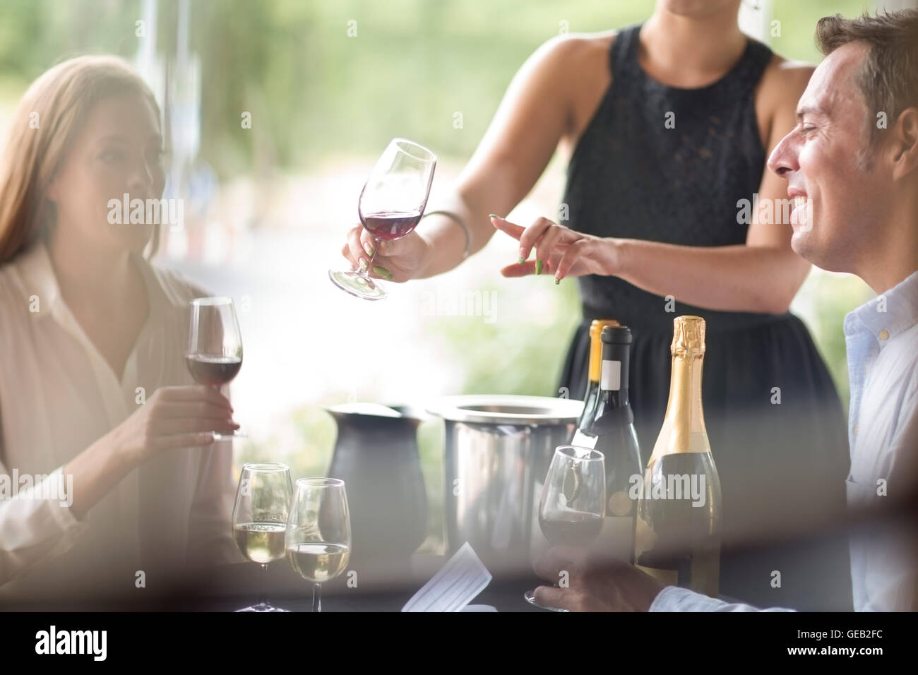 Waitress in restaurant presenting red wine Stock Photo