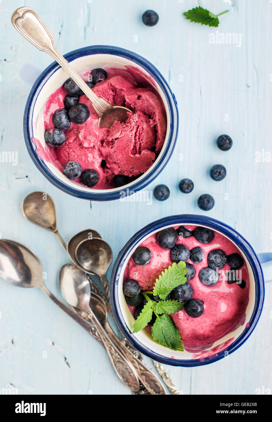 Homemade blueberry ice cream scoops with fresh berries and mint leaves