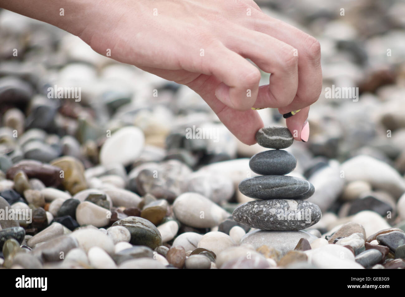 balancing stones with woman hand Stock Photo - Alamy