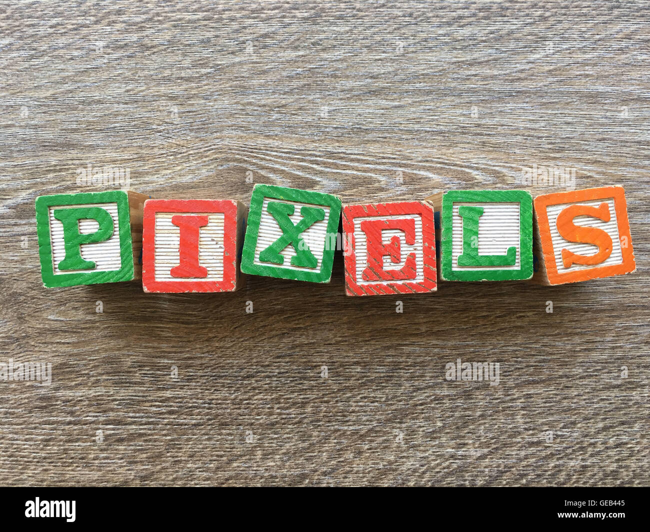 Wood blocks or wooden cubes toys with alphabet letters on them combined together to create the word PIXELS Stock Photo