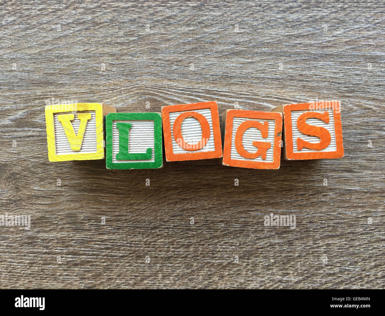 Alphabet wood block letters forming the word VLOGS, combining those toys letters help kids to learn and write english Stock Photo