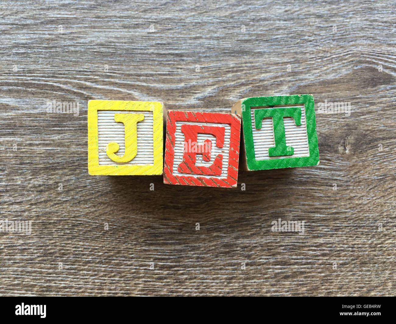 Alphabet wood block letters forming the word JET, combining those toys