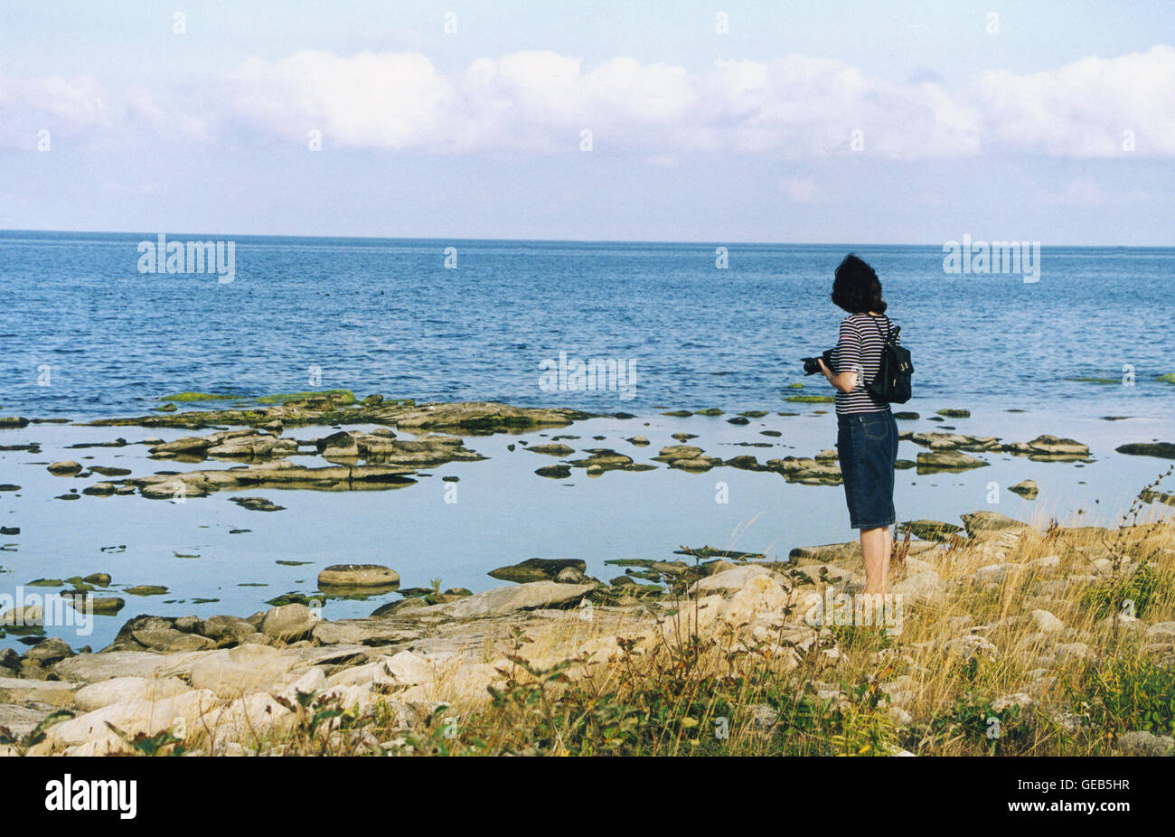 Shoreline and woman with camera Stock Photo