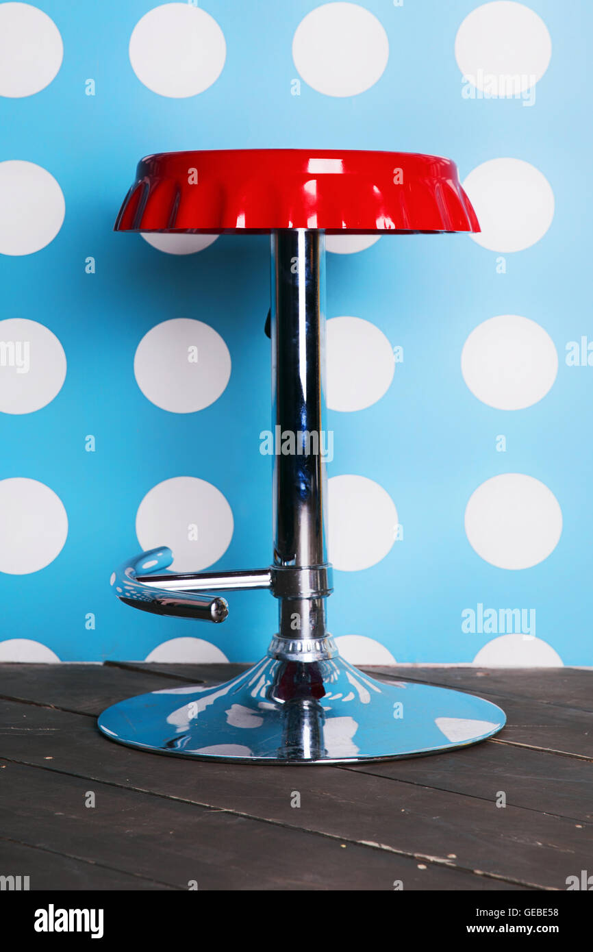 Red bar stool against a background of wall Stock Photo - Alamy