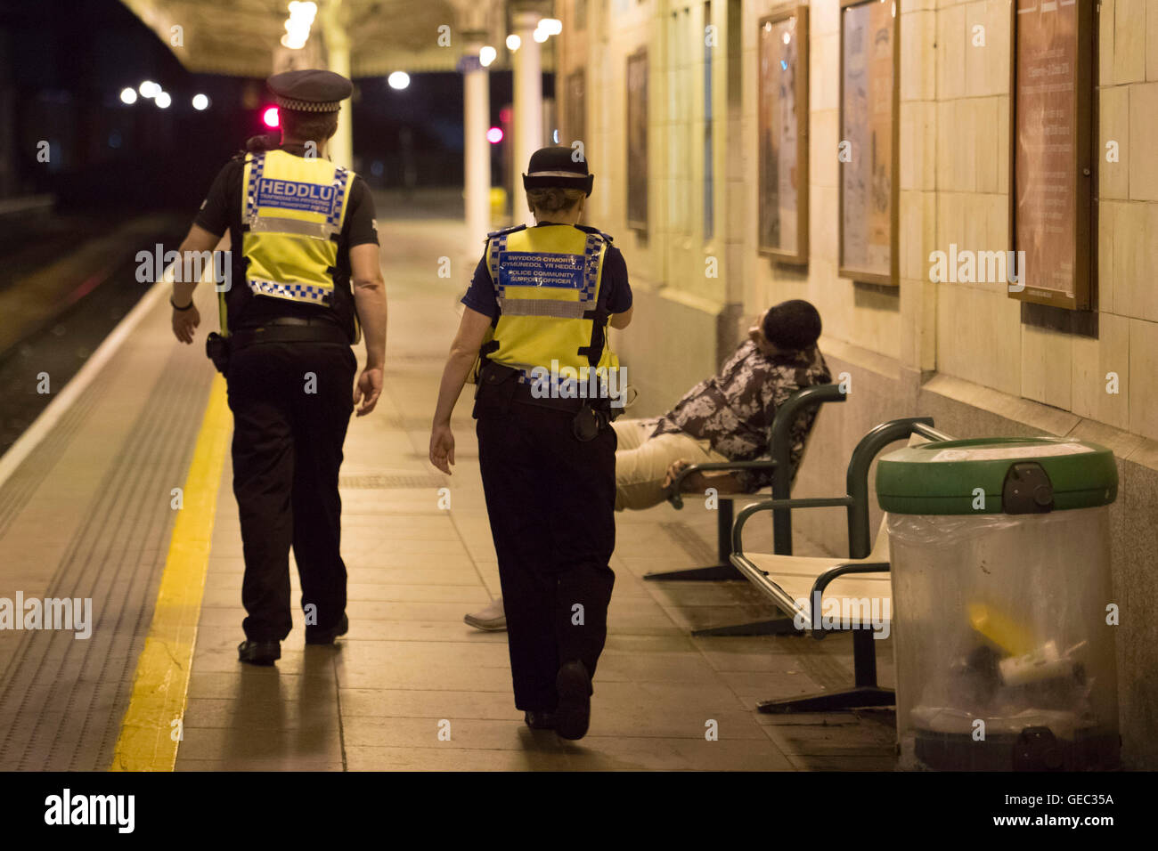 CARDIFF, WALES - JULY 22: British Transport Police help a man asleep on a bench on the platform while on patrol at Cardiff Centr Stock Photo