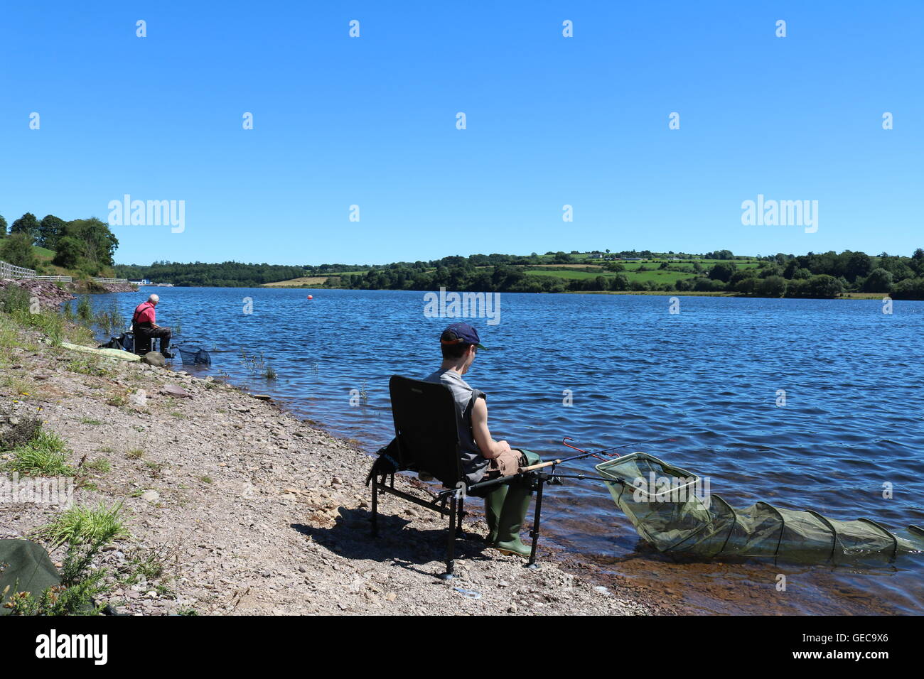 Two Anglers Fishing With Swimfeeder Rods For Roach And Bream In