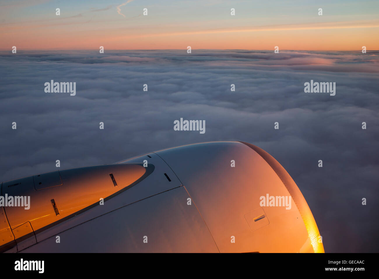Sunset from the clouds across the engine of a Ryanair plane as it flies ...