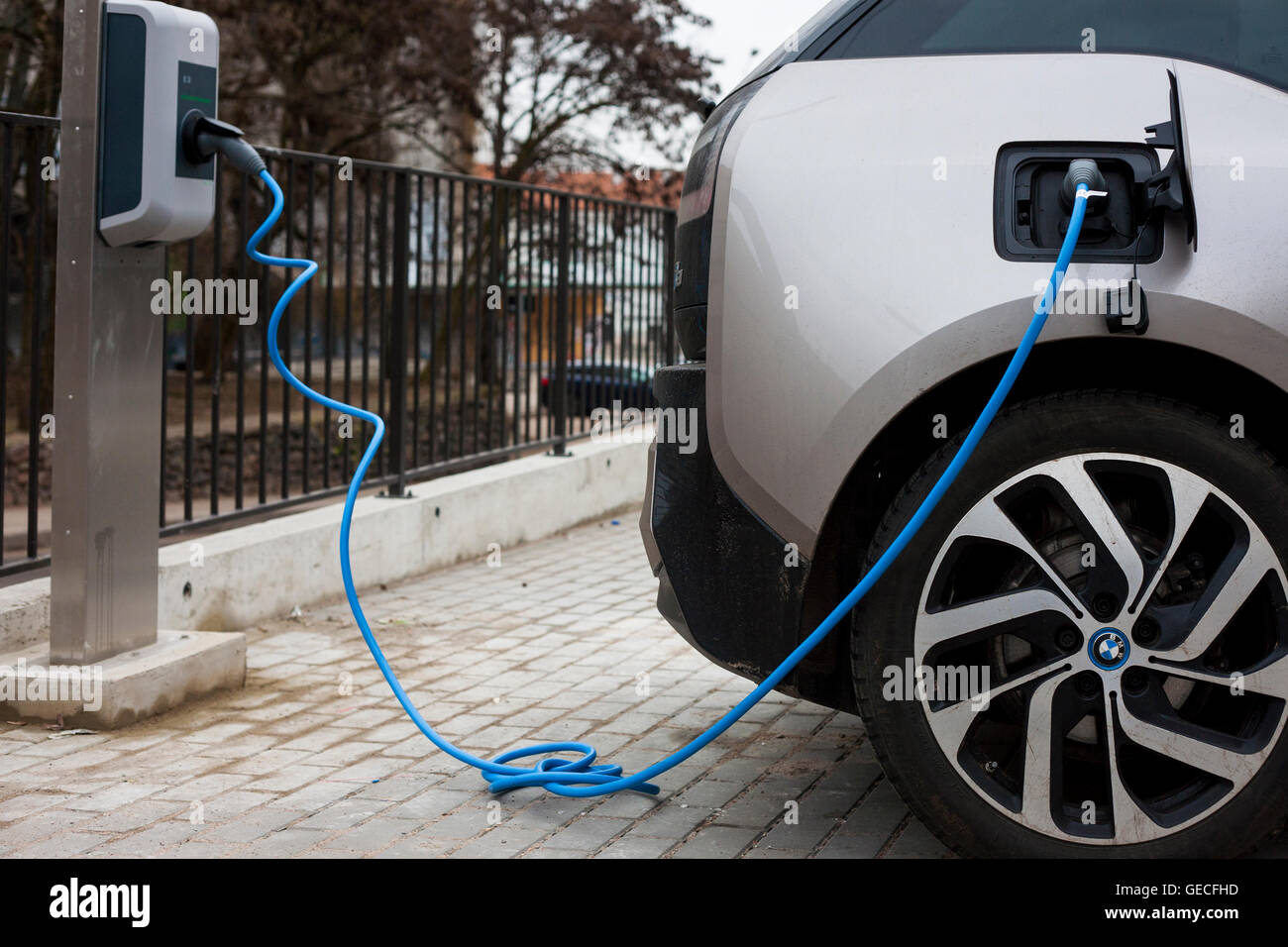 An electric hybrid BMW motor car charges up at a charging point in