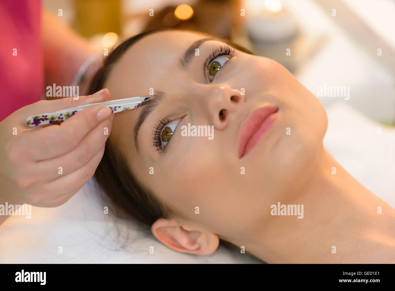 Attractive woman getting tweezing procedure at beauty salon Stock Photo