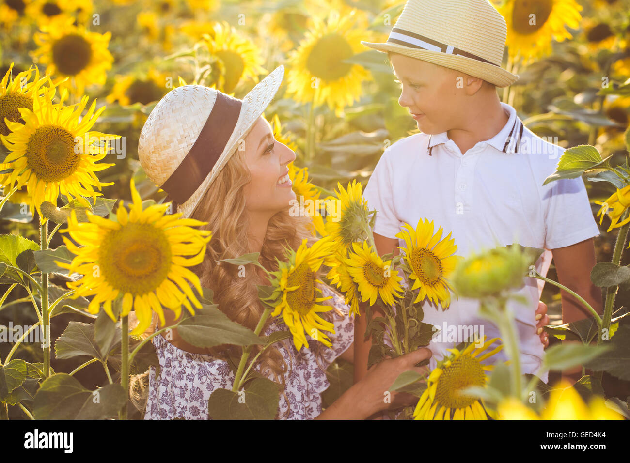 Beautiful woman with son in sunflower field Stock Photo - Alamy