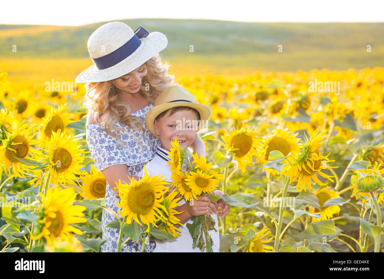 Beautiful woman with son in sunflower field Stock Photo - Alamy