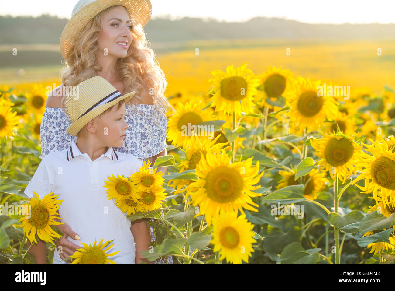Beautiful woman with son in sunflower field Stock Photo - Alamy