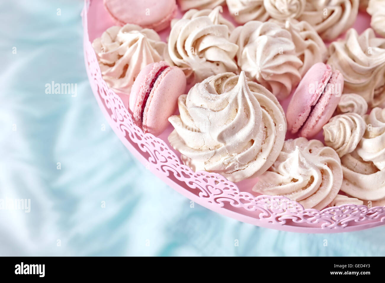 Homemade pink and white meringues on a plate, space for text. Stock Photo