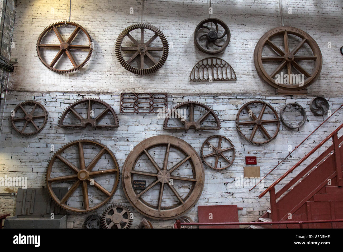 Wooden molds for the casting of iron wheels, hanging on the walls of a room inside the National Slate Museum in Llanberis, Wales Stock Photo
