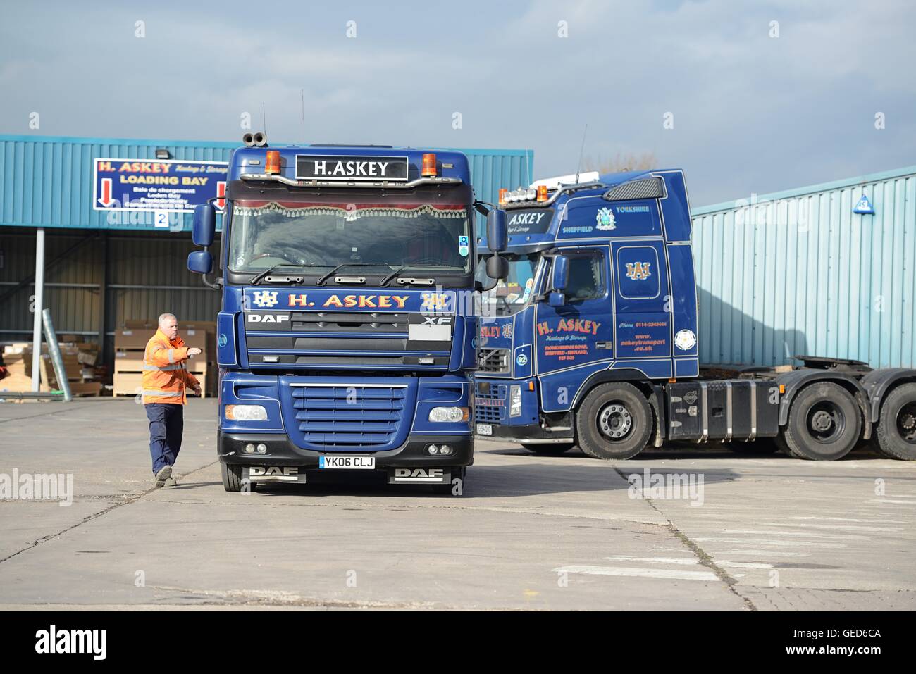 Driver in a truck cab talking to the yard man in a haulage firm yard Stock Photo